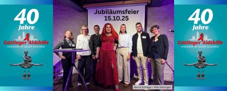 Das Bild zeigt das Team der Göttinger Aidshilfe - Vorstand & Haupamtliche - zusammen mit der Moderatorin & Drag-Queen Renelopé Fauxwell